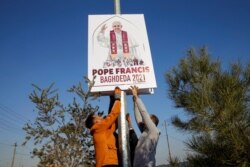 Christians volunteers decorate streets with the pictures of Pope Francis, ahead of his planned visit to to Iraq, in Qaraqosh, Iraq, Feb. 22, 2021.