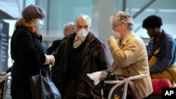 Passengers arrive on a flight from Germany at Logan International Airport in Boston, March, 13, 2020.