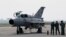 FILE - A ground crew stands on the tarmac by a MiG-21 fighter jet at the military airport Batajnica, near Belgrade, Serbia, April 6, 2016. Serbia has recently procured six MiG-29 jets, 30 tanks and armored personnel carriers from Russia.