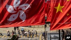 Bendera China dan Hong Kong berkibar di Hong Kong, 1 Oktober 2023. China pmenuduh Inggris dan AS “berniat jahat” setelah mereka mengecam polisi Hong Kong karena menawarkan imbalan atas informasi yang akan mengarah pada penangkapan lima aktivis di luar negeri. (Foto: AP)