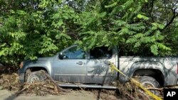 Puing-puing melingkupi sebuah mobil setelah banjir menerjang wilayah Plainfield, Vermont, pada 11 Juli 2024, akibat terjangan topan Beryl ke wilayah tersebut. (Foto: AP/Lisa Rathke)