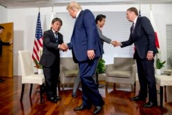 U.S President Donald Trump shakes hands with Japanese Economy Minister Toshimitsu Motegi, left, and Japanese Prime Minister Shinzo Abe, second from right, shake hands with U.S. Trade Rep. Robert Lighthizer, at the G-7.