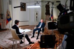 Russian President Vladimir Putin speaks to NBC News journalist Keir Simmons, back to a camera, in an interview that aired, June 14, 2021. (Maxim Blinov, Sputnik, Kremlin Pool Photo via AP)