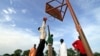 FILE - A basketball team plays a game before the arrival of the body of Sudan-born NBA star Manute Bol in the town of Turalei in Warap state, southern Sudan.