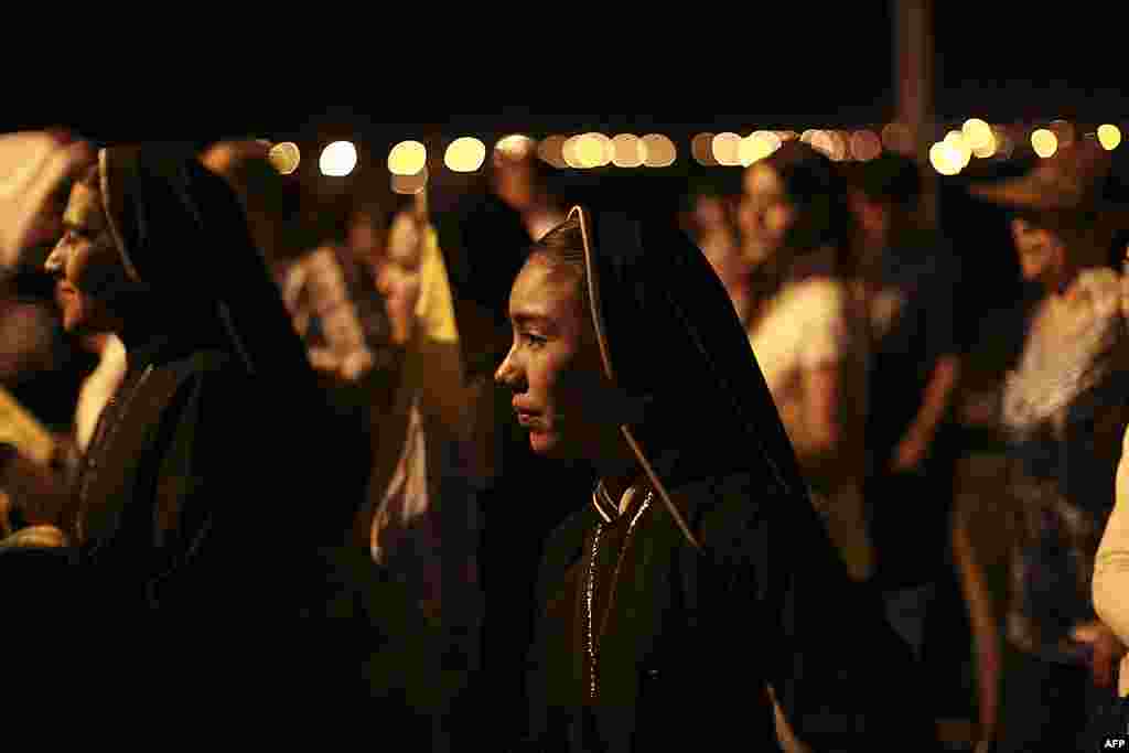 Nuns walk alongside pilgrims as they travel up a road to the site where Pope Benedict will give Sunday Mass at the Bicentennial Park near Silao, Mexico, March 24, 2012.(AP)