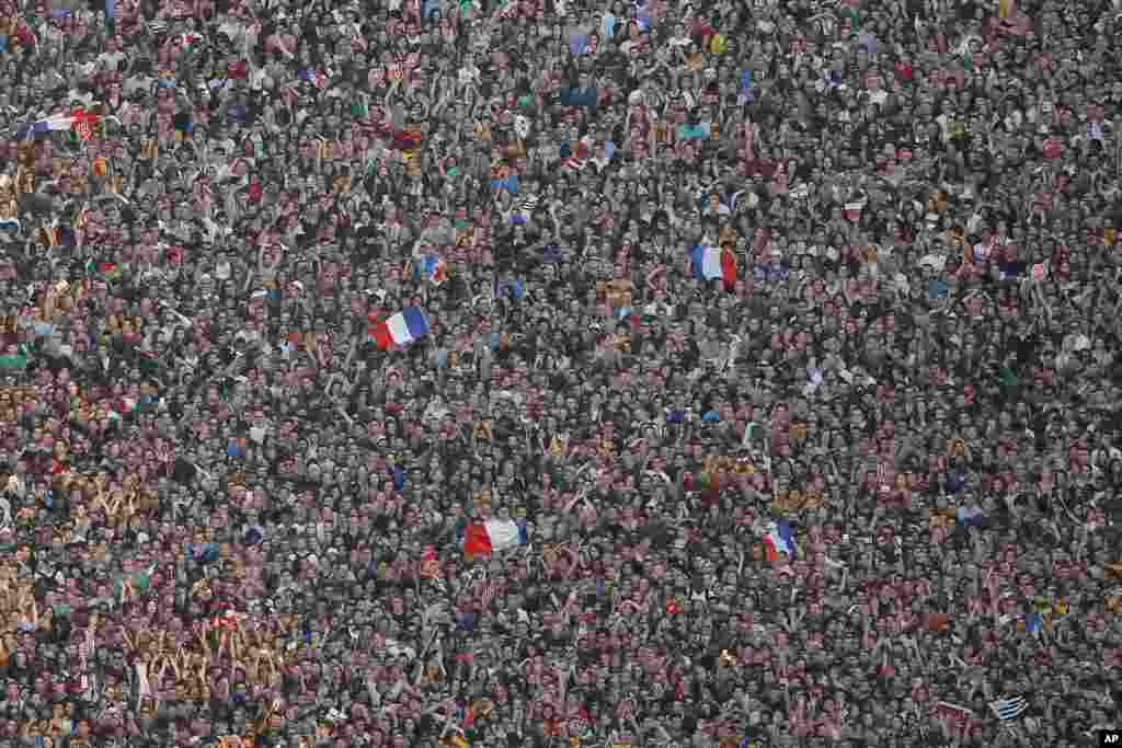 Fans waving French flags attend a concert in the soccer fan zone near the Eiffel Tower, as part of the upcoming Euro 2016 Soccer Championship in Paris, June 9, 2016.