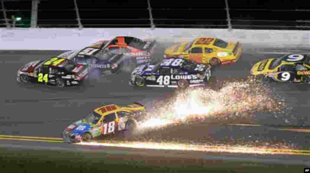 Kyle Busch (18) slides sideways to avoid a wreck as Jeff Gordon (24) heads to the wall before his car slid on its side and then rolled, during the NASCAR Budweiser Shootout auto race at Daytona International Speedway, Saturday, Feb. 18, 2012, in Daytona B