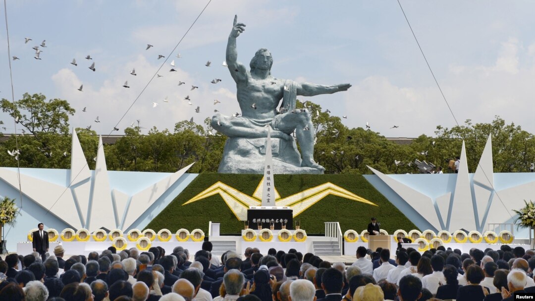 Burung merpati terbang melewati Patung Perdamaian di Taman Perdamaian Nagasaki dalam upacara peringatan 70 tahun pemboman kota tersebut, di Nagasaki, Jepang barat. Foto oleh Kyodo, 9 Agustus 2015. 