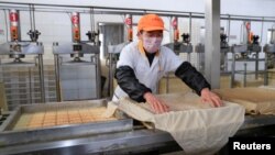 Un trabajador usa una máscara protectora en una fábrica de productos de soja en Hefei, provincia de Anhui, China, el 4 de febrero de 2020.