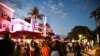 People gather on Ocean Drive in Miami Beach, on March 22, 2021. The city of Miami Beach, overrun by crowds of spring break tourists, has extended a state of emergency to stem the chaos.