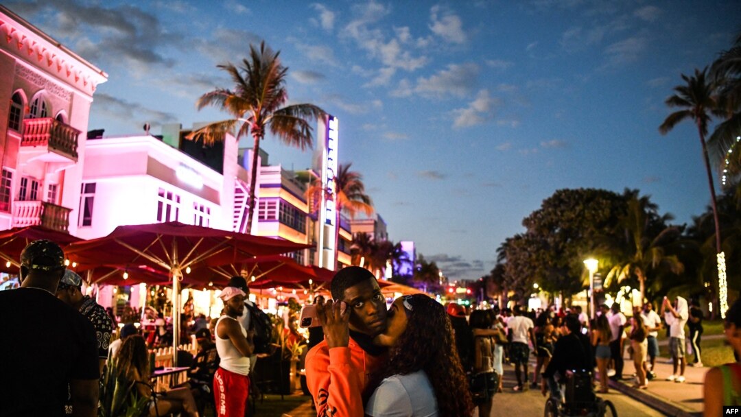 People gather on Ocean Drive in Miami Beach, on March 22, 2021. The city of Miami Beach, overrun by crowds of spring break tourists, has extended a state of emergency to stem the chaos.