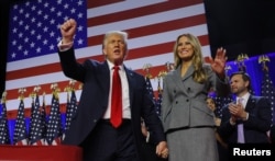 Calon presiden dari Partai Republik dan mantan Presiden AS Donald Trump mengepalkan tangannya ditemani oleh istrinya Melania di Palm Beach County Convention Center, West Palm Beach, Florida, Amerika Serikat, 6 November 2024. (Brian Snyder/REUTERS)