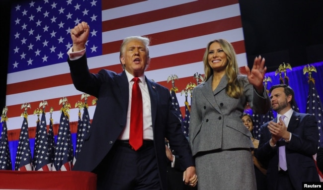 Calon presiden dari Partai Republik dan mantan Presiden AS Donald Trump mengepalkan tangannya ditemani oleh istrinya Melania di Palm Beach County Convention Center, West Palm Beach, Florida, Amerika Serikat, 6 November 2024. (Brian Snyder/REUTERS)