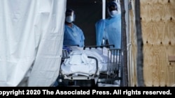 6일 미국 뉴욕 브루클린의 와이코프 하이츠 메디컬 센터 직원들이 신종 코로나바이러스 감염증(COVID-19) 사망자들의 시신을 옮기고 있다. 