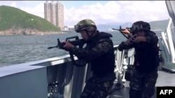 This screengrab taken from undated handout three-minute promotional video received on Aug. 1, 2019, from China's People's Liberation Army (PLA) Hong Kong Garrison shows armed PLA soldiers on a boat during a drill in Hong Kong waters. 