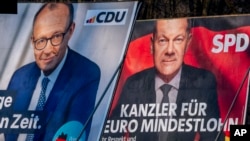 Cartazes eleitorais que mostram o chanceler alemão Olaf Scholz, à direita, e o principal candidato da CDU a chanceler Friedrich Merz em Frankfurt, Alemanha, 8 de fevereiro de 2025.