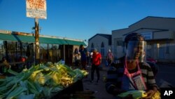 Gogo Zitha, usando una mascarilla para evitar la contaminación con el nuevo coronavirus, vende maíz tostado en la calle en Katlehong, al este de Johanesburgo, Sudáfrica el 6 de mayo de 2020.