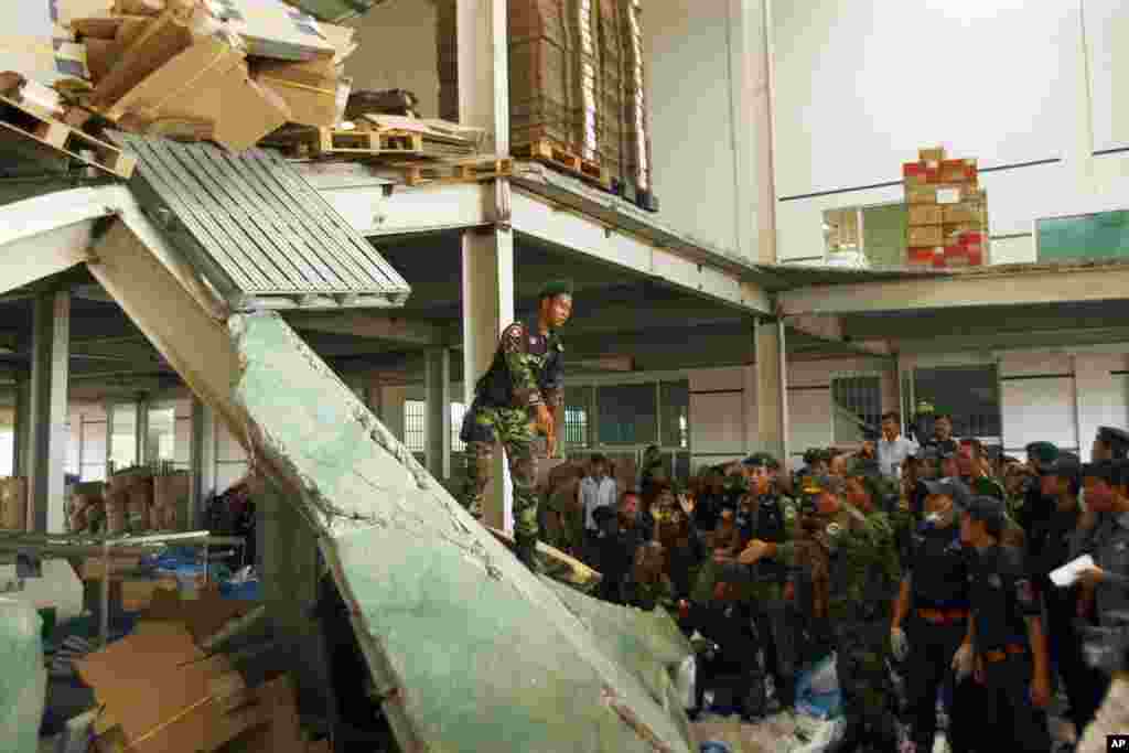 Cambodian rescuers work at the site of a factory collapse in Kai Ruong village, south of Phnom Penh, May 16, 2013. 