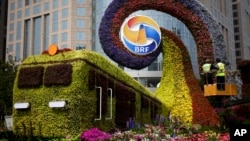 Workers on a platform install flowers on a display in a shape of a train to promoting the upcoming Belt and Road Forum in Beijing, China, April 23, 2019.