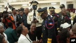 FILE - Haitian Police Chief Frantz Elbe, front, greets the relatives of three police officers who died in the line of duty, during the wake in Delmas, Haiti, on April 21, 2023. Haitian leaders fired Elbe on June 15, 2024.