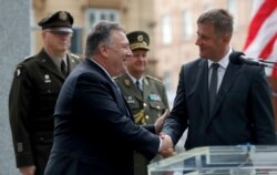 U.S. Secretary of State Mike Pompeo, front left, shakes hands with Czech Republic's Foreign Minister Tomas Petricek, right, during a ceremony at the General Patton memorial in Pilsen near Prague, Czech Republic, Aug. 11, 2020.