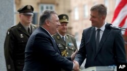 U.S. Secretary of State Mike Pompeo, front left, shakes hands with Czech Republic's Foreign Minister Tomas Petricek, right, during a ceremony at the General Patton memorial in Pilsen near Prague, Czech Republic, Aug. 11, 2020.