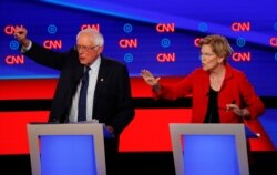 FILE - Sen. Bernie Sanders, I-Vt., and Sen. Elizabeth Warren, D-Mass., talk during in the first of two Democratic presidential primary debates hosted by CNN in the Fox Theatre in Detroit, July 30, 2019.