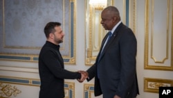 En esta foto proporcionada por el servicio de prensa del presidente de Ucrania el 21 de octubre de 2024, el secretario de Defensa de Estados Unidos, Lloyd Austin, a la derecha, y el presidente de Ucrania, Volodymyr Zelenskyy, se dan la mano durante su reunión en Kiev, Ucrania.