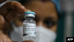 Seorang staf kesehatan menunjukkan botol vaksin COVID-19 pertama India, "Covaxin" di Kolkata Medical College dan Rumah Sakit di Kolkata, 3 Februari 2021. (Foto oleh DIBYANGSHU SARKAR / AFP)