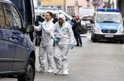 Forensic officers carry evidence from one of two hookah bars where several people were killed on Wednesday night, in Hanau, Germany, Feb. 20, 2020.