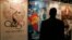 FILE - A visitor looks at posters of productions of China International TV Corporation at "Filmart," a part of Entertainment Expo Hong Kong. 