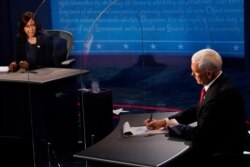 FILE - Vice President Mike Pence takes notes as then-Democratic vice presidential candidate Kamala Harris answers a question during the vice presidential debate, Oct. 7, 2020, at the University of Utah in Salt Lake City.