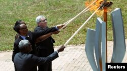 Moussa Faki Mahamat, presidente de la Comisión de la Unión Africana, Paul Kagame, Presidente de Ruanda, Jeannette Kagame y el presidente de la Comisión Europea, Jean-Claude Juncker, encienden la llama de la esperanza durante la conmemoración del 25 aniversario del genocidio.