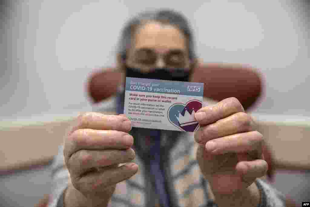 بیاسی سالہ خاتون برنیس وائنر لندن کے رائل فری اسپتال میں ویکسین کی خوراک لینے کے بعد اپنا کارڈ تھامے ہوئے ہیں۔ 