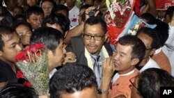 A leader in the Burmese democratic movement, Moe Thee Zun, center, is surrounded by greeting supporters upon his arrival at Yangon International Airport in Rangoon, Burma, September 1, 2012. 