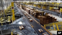 Paket-paket yang siap dikirim ke pelanggan tampak menaiki sistem konveyor di pusat pengiriman Amazon di Baltimore, Maryland (foto: ilustrasi). 