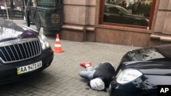 Un presunto asesino, que mató al ex legislador ruso Denis Voronenkov, yace herido en el suelo en una calle de Kiev, capital de Ucrania, el jueves 23 de marzo.
