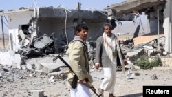 Pemberontak Houthi memeriksa lokasi serangan udara Saudi di kota Saada (30/3). Situasi Yaman yang memburuk memaksa PBB menarik seluruh staf internasionalnya dari sana.