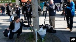 Građani polažu cveće na Šanzelizeu u Parizu, gde je ubijen jedan policajac a dvojica ranjena