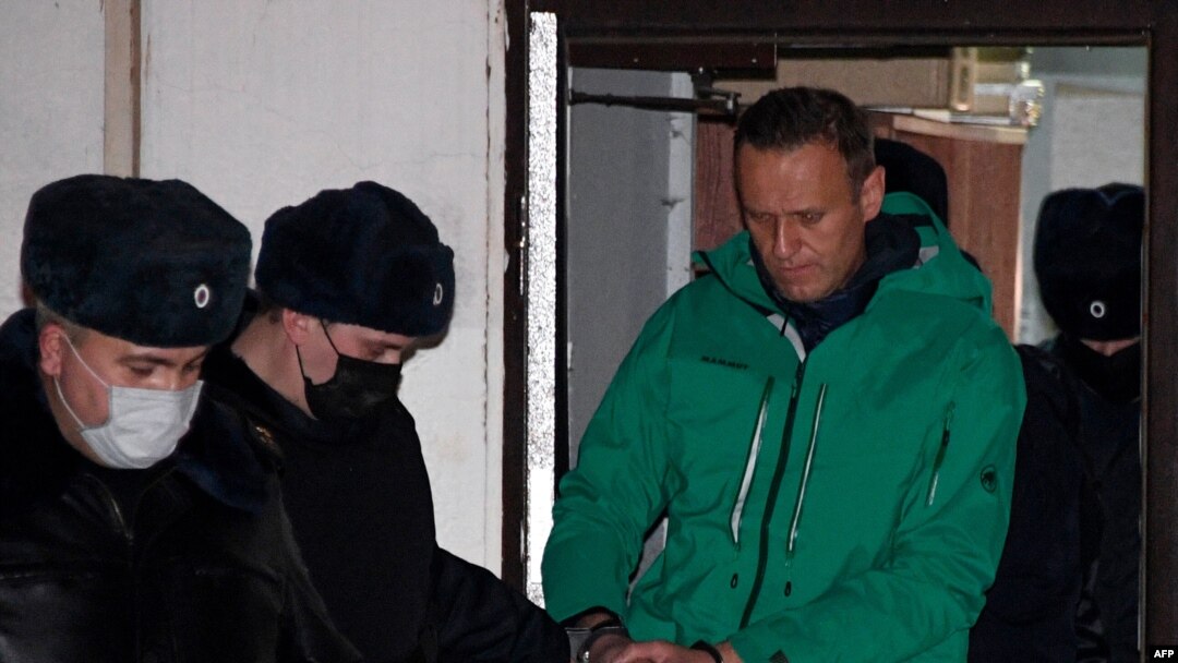 Opposition leader Alexei Navalny is escorted out of a police station on Jan. 18, 2021, in Khimki, outside Moscow, following the court ruling that ordered him jailed for 30 days.