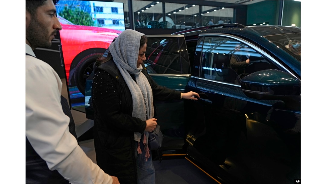 Tahran'da düzenlenen otomobil fuarında bir ziyaretçi araçları inceliyor- 30 Ocak 2025.