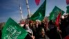 Sejumlah demonstran membawa bendera Hamas dalam aksi protes menunjukkan dukungan terhadap Palestina dan menyerukan gencatan senjata di Gaza. Aksi protes berlangsung di Istanbul, Turki, pada 14 Januari 2024. (Foto: AP/Emrah Gurel) 