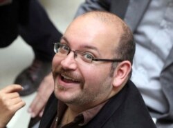 FILE - Jason Rezaian, an Iranian-American correspondent for the Washington Post, smiles as he attends a presidential campaign of President Hassan Rouhani in Tehran, April 11, 2013.