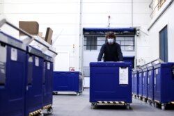 An employee of Cryonomic, a Belgium company producing dry ice machines and containers that will be used for COVID-19 vaccine transportation, pushes a medical dry ice container in Ghent, December 2, 2020.