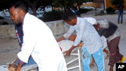 Medical workers help a person on a stretcher who was wounded in a suicide bombing at Madina hospital, Mogadishu, July 24, 2019. 