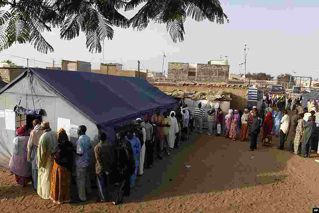 Voters wait in line to cast their votes outside tents erected to serve as polling stations, in the Guediawaye neighborhood of Dakar, March 25, 2012. (AP)