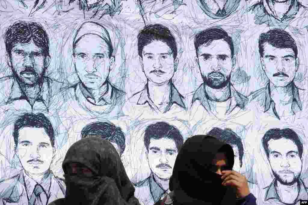 Kashmiri members of the Association of Parents of the Disappeared (APDP) take part in a protest in front of a banner depicting those missing during a demonstration in Srinagar. Indian forces in Kashmir are often blamed for grave rights abuses like widespread torture, rape, custodial murder and enforced disappearences in the Muslim-majority region which is divided and administered separately by India and Pakistan but claimed in full by both.