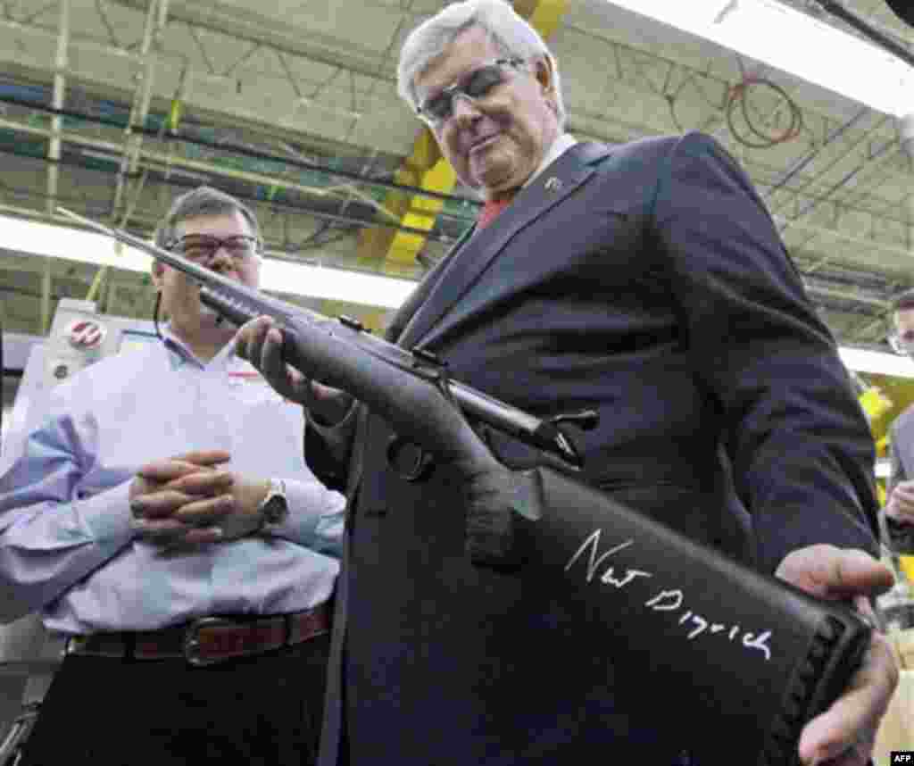 Republican presidential candidate, former House Speaker Newt Gingrich holds a rifle that he signed for Tom Sullivan, left, vice president of plant operations at Sturm, Ruger & Co., the maker of Ruger firearms, Friday, Jan. 6, 2012, in Newport, N.H. (AP Ph
