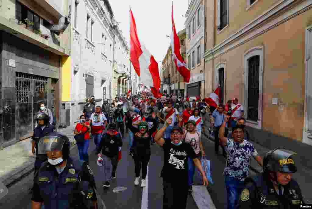 La gente grita y ondea banderas mientras participa en una protesta después de que el Congreso aprobara la destitución del presidente Pedro Castillo, en Lima, Perú, el 7 de diciembre de 2022. REUTERS/Alessandro Cinque