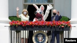 U.S. President Joe Biden waves next to first lady Jill Biden and a person wearing an Easter Bunny costume at the Blue Room Balcony of the White House in Washington, U.S. April 5, 2021. REUTERS/Kevin Lamarque